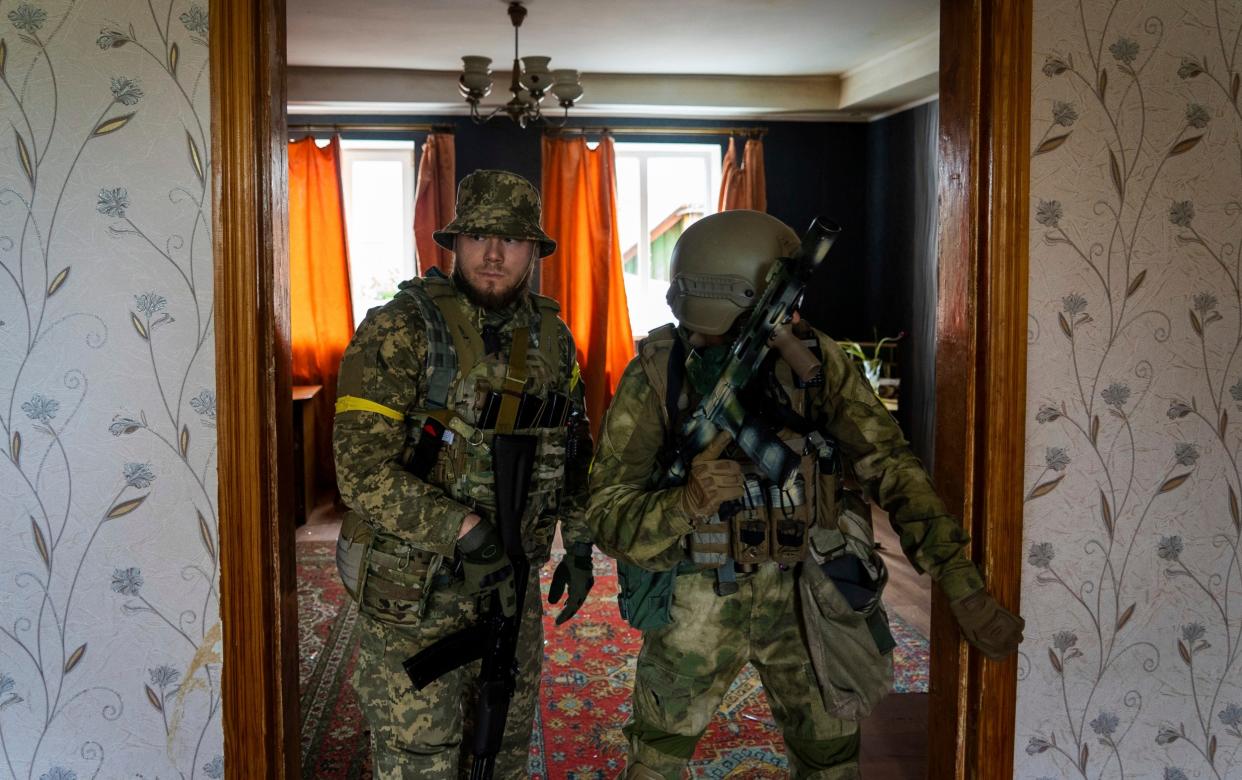 Ukrainian servicemen inspect a house during a reconnaissance mission in a recently retaken village on the outskirts of Kharkiv on Saturday - Mstyslav Chernov/AP