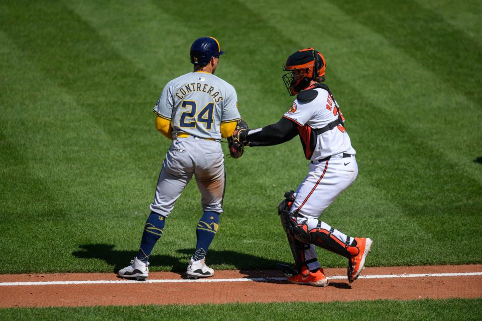 Orioles catcher Adley Rutschman tags Brewers catcher William Contreras who was trying to score on a grounder with the infield drawn in during the fifth inning Sunday at Camden Yards.