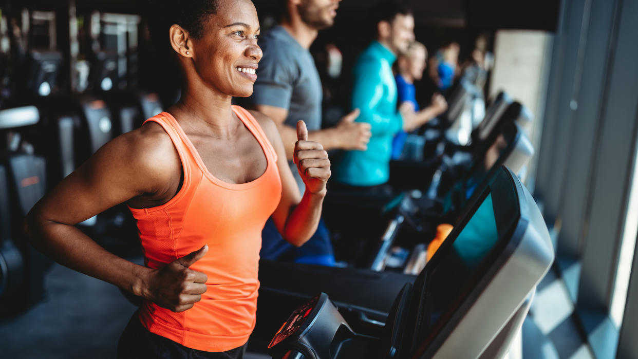  Happy beautiful woman smiling and working out in gym. 