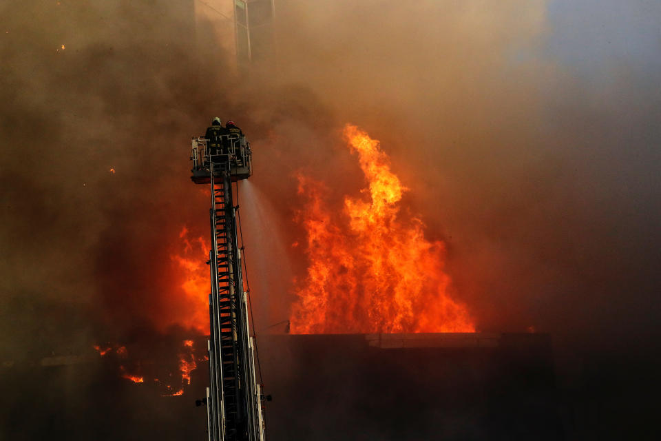 Firemen work to put out flames from a burning building during an anti-government protest in Santiago, Chile on Oct. 28, 2019. (Photo: Henry Romero/Reuters)