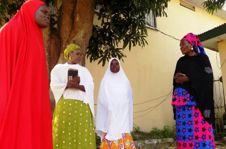 Councillors speak to Hafsat Ibrahim (L) and Fatima Salisu (2-R), who were held captive for over 12 months and forcibly married to Boko Haram Islamists