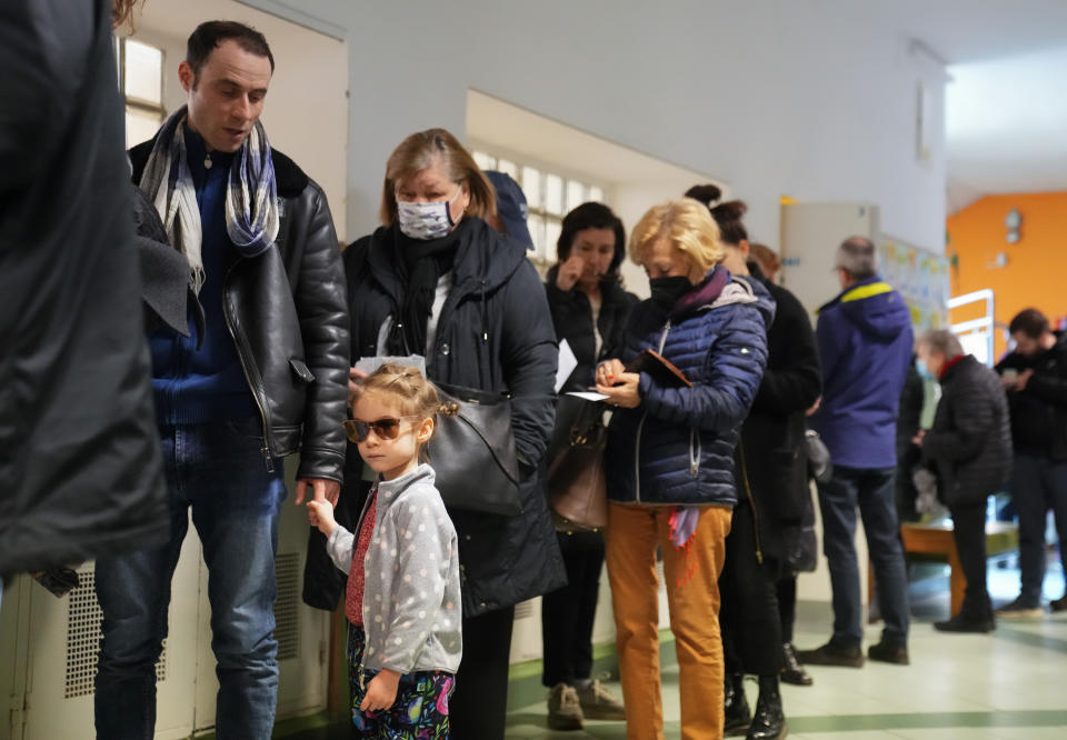 People queue to vote in general election in Budapest, Hungary, Sunday, April 3, 2022. Hungary's nationalist prime minister Viktor Orban seeks a fourth straight term in office, a coalition of opposition parties are framing the election as a referendum on Hungary's future in the West. (AP Photo/Petr David Josek)