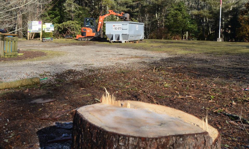 Cesar DeSousa loads up old landscaping timbers Wednesday as work gets underway at a renovation project on the grounds of the Armstrong-Kelley Park in Osterville.