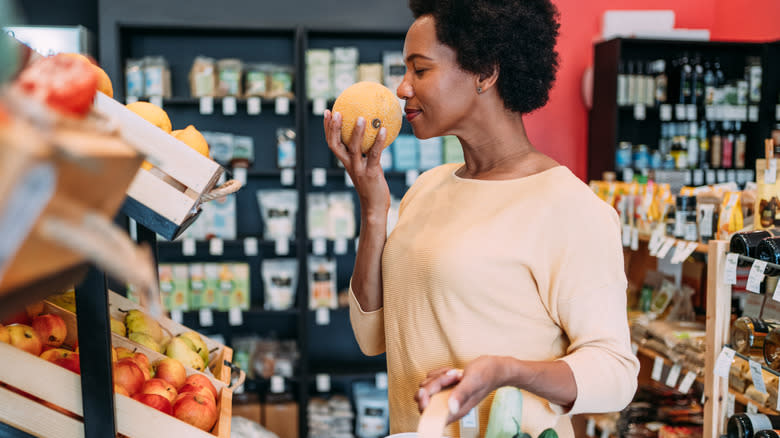 Shopper smelling fruit at a grocery store