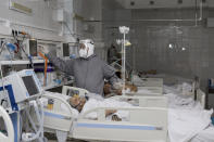 A medical worker looks at a monitor treating a coronavirus patient on an artificial lung respiration at an intensive care unit in the red zone of the hospital in Ulan-Ude, the regional capital of Buryatia, a region near the Russia-Mongolia border, Russia, Friday, Nov. 20, 2020. Russia’s health care system has been under severe strain in recent weeks, as a resurgence of the coronavirus pandemic has swept the country. (AP Photo/Anna Ogorodnik)