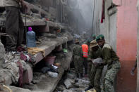 <p>Kenyan National Youth Service personnel remove stones by hand at the site of a building collapse in Nairobi, Kenya, April 30, 2016. <i>(Photo: Sayyid Abdul Azim/AP)</i></p>