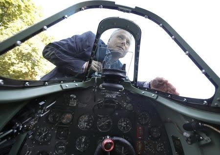 Pilot John Romain looks in the windscreen of a Mk.1 Spitfire, donated by American entrepreneur and philanthropist, Thomas Kaplan, on display outside the Churchill War Rooms in London, Britain July 3, 2015. REUTERS/Peter Nicholls