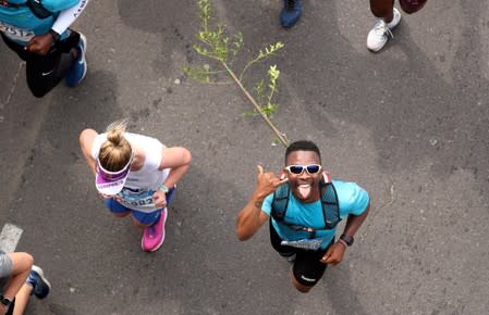 Activist and treegrower Sokomani celebrates as he approaches the final stretch of the Cape Town marathon
