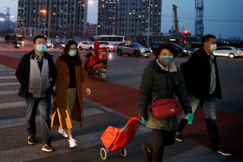 People wear face masks outside a shopping mall in Beijing as the country is hit by an outbreak of the novel coronavirus