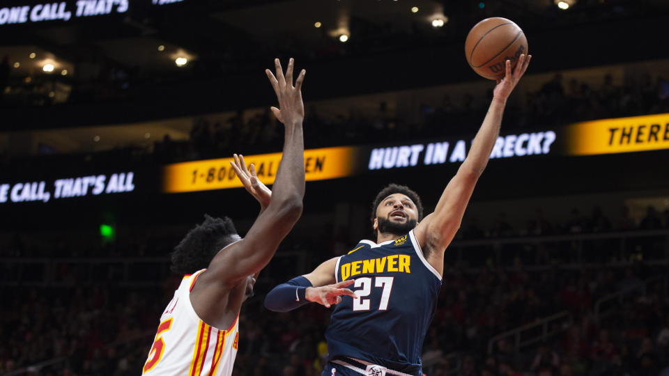 Denver Nuggets guard Jamal Murray (27) scores against Atlanta Hawks center Clint Capela, left, during the second half of an NBA basketball game Friday, Dec. 2, 2022, in Atlanta. (AP Photo/Hakim Wright Sr.)