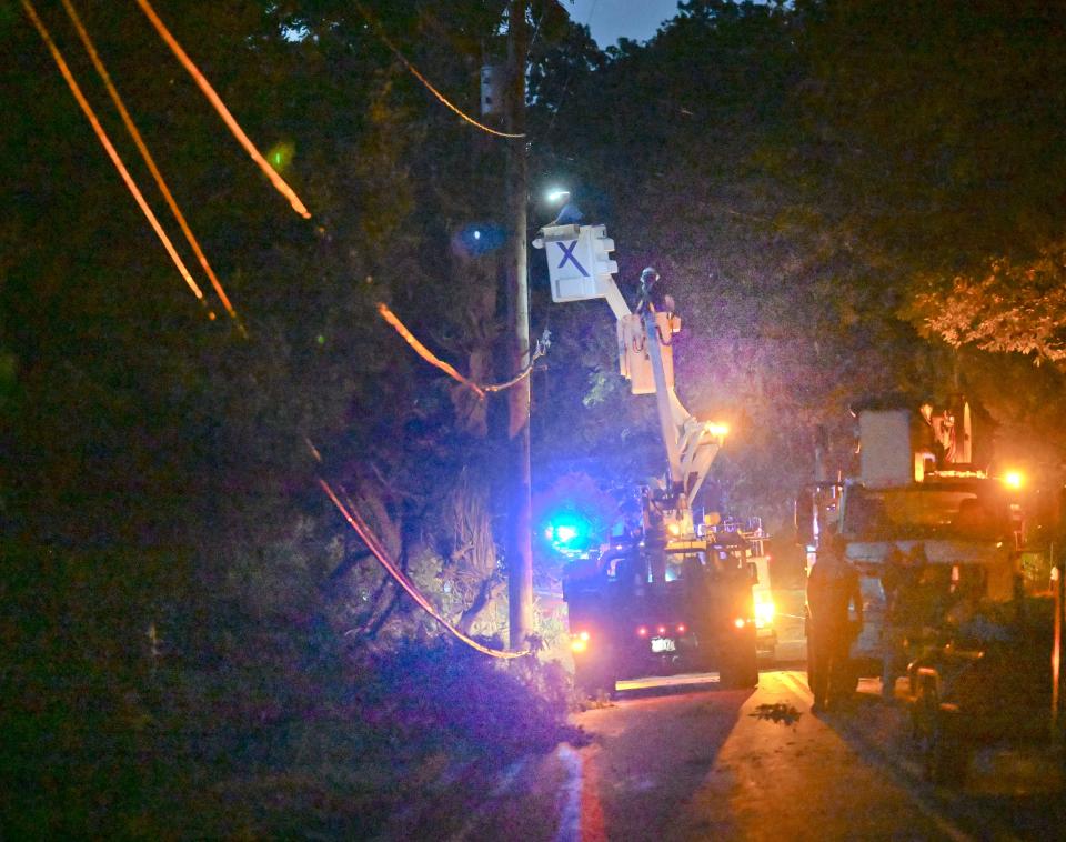 Cable television utility workers reconnect wires on new utility poles Tuesday evening on Osterville-West Barnstable Road in Marstons Mills.  A "small" tornado, according to the National Weather Service, came across a nearby horse farm, knocking down fences and utility poles.