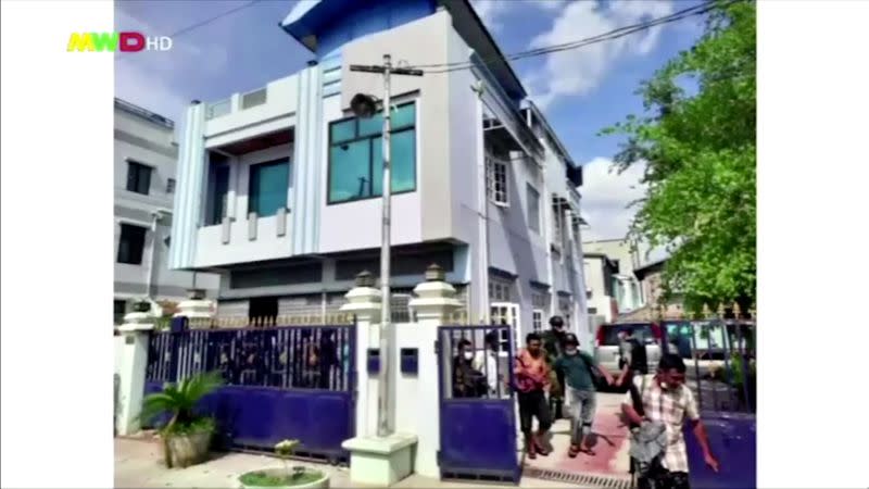 People walk out from a house believed to have been raided by security forces, in Mandalay