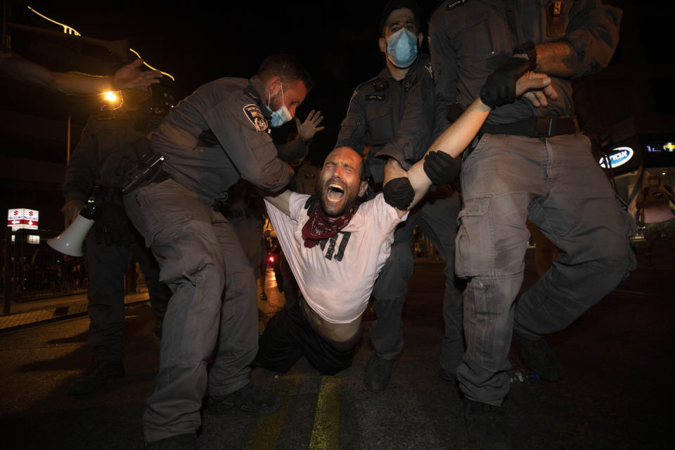 Israeli police officers detain an Israeli protester during a demonstration against lockdown measures that they believe are aimed at curbing protests against prime minister Benjamin Netanyahu in Tel Aviv, Israel, Thursday, Oct. 1, 2020. (AP Photo/Sebastian Scheiner)