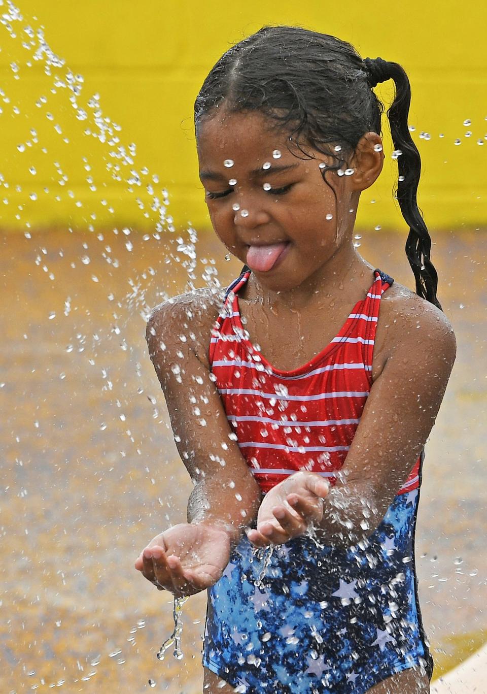 People used to go outside to stay cool. Now they stay inside. Here, four-year-old Ariana Lopez enjoys a cool spray in Yuma, Arizona.