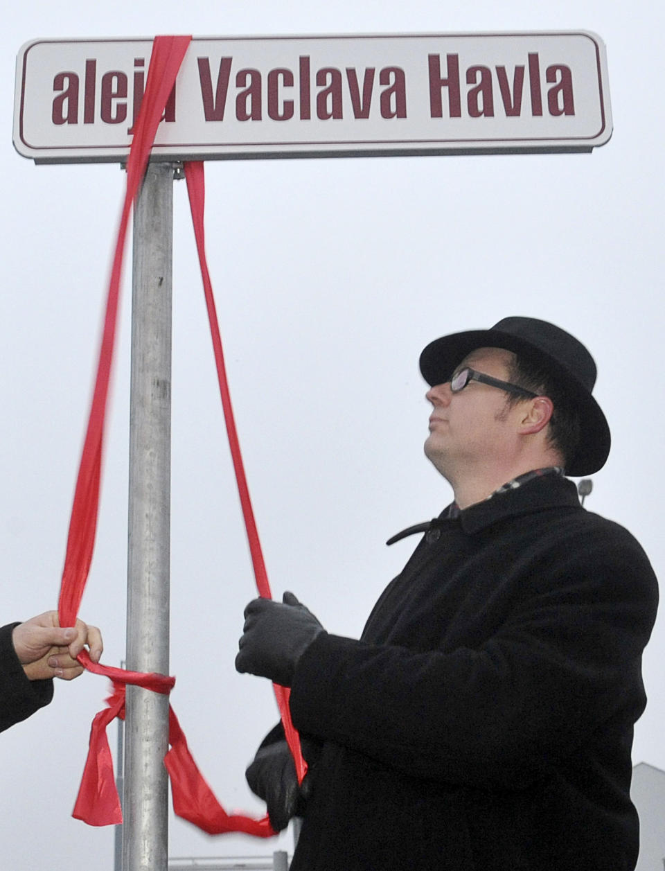 FILE - In this Friday, Dec. 23, 2011 file photo, Gdansk Mayor Pawel Adamowicz unveils a street renamed in honor of Vaclav Havel, the former Czech president and playwright, in Gdansk, Poland. Poland's health minister says that Gdansk Mayor Pawel Adamowicz has died from stab wounds a day after being attacked onstage by an ex-convict at a charity event, it was reported on Monday, Jan. 14, 2019. (AP Photo/Maciej Kosycarz, File)