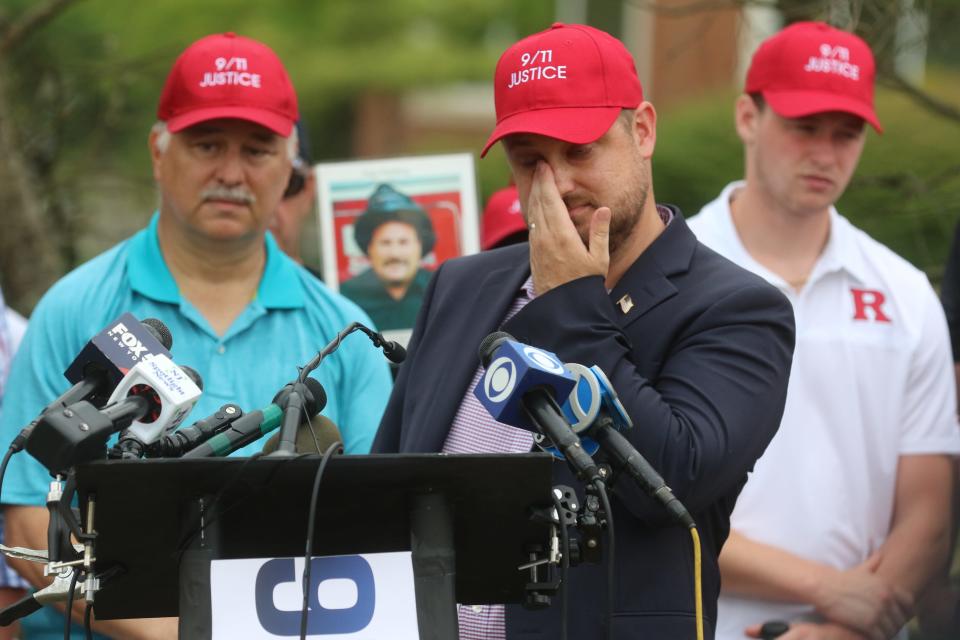 Brett Eagleson, President of 9/11 Justice.org wipes a tear as  he addressed the media with members and supporters of 9/11 Justice as they held a gathering outside the Clarence Dillon Library in Bedminster to address the media concerning their opposition to Saudi support for the LIV Golf Tournament being held at Trump National in Bedminster, NJ on July 29, 2022.