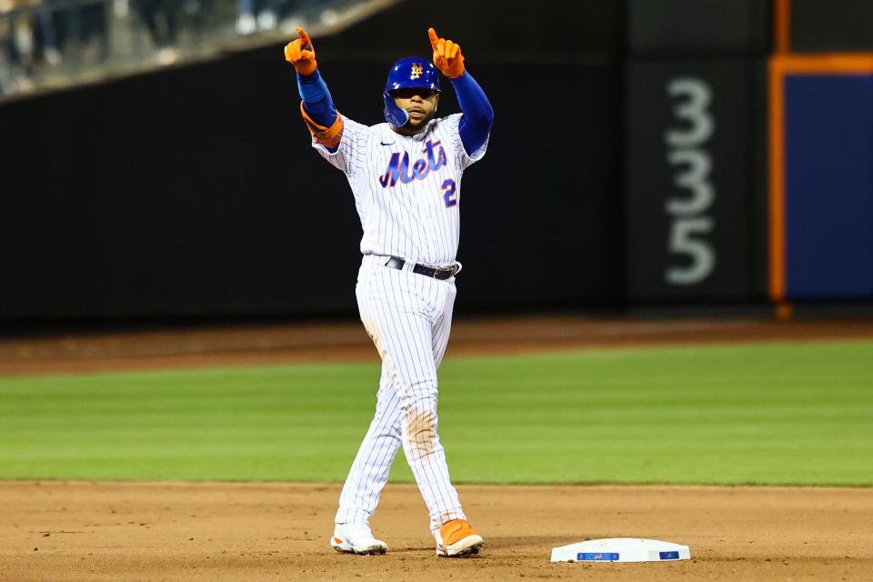 New York Mets' Dominic Smith (2) signals to the dugout after hitting an RBI double to drive in Mets' Eduardo Escobar against the Philadelphia Phillies during the fourth inning of a baseball game, Sunday, May 1, 2022, in New York.