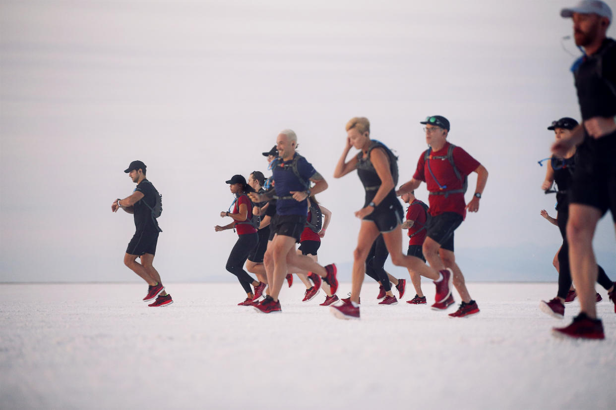 Runners, including professional athletes, set off at sunrise in the Eternal Run at the Bonneville Salt Flats, Utah, USA. (Credit: ASICS).