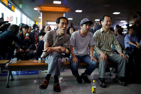 People watch a TV broadcasting a news report on summit between the U.S. and North Korea, in Seoul, South Korea, June 12, 2018. REUTERS/Kim Hong-Ji