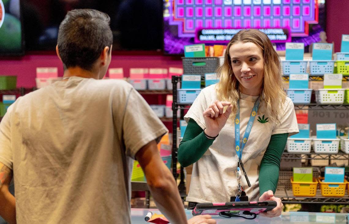 Lily Johnson, a budtender at Fresh Green Dispensary, helps a customer select products on Friday, Feb. 3, 2023, in Kansas City.