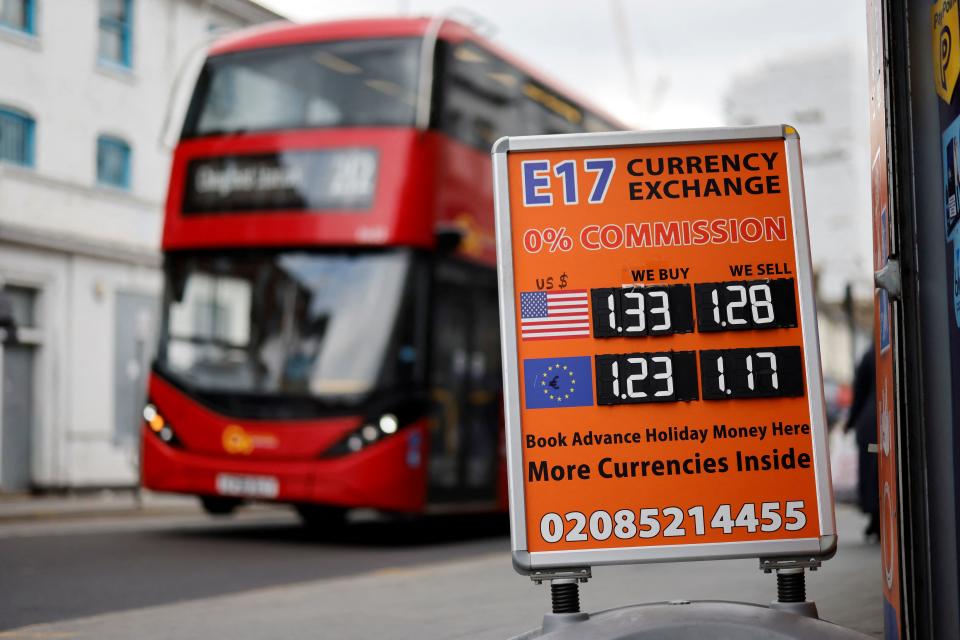 A bus drives past a board indicating exchange currencies between the Sterling and the US Dollar and Euros, in Central London on April 22, 2022. - The pound slumped more than one percent against the dollar on April 22, 2022 after official data showed tumbling retail sales as Britons grapple with a cost-of-living crisis. In London morning deals, sterling sank to $1.2887 -- its lowest level since October 2020, also as Britain's Prime Minister comes under renewed political pressure. (Photo by Tolga Akmen / AFP) (Photo by TOLGA AKMEN/AFP via Getty Images)