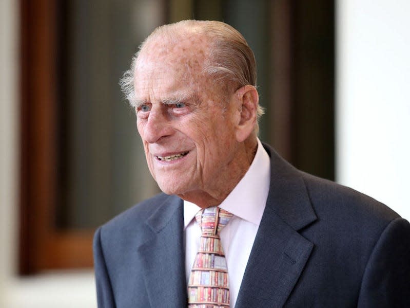 Prince Philip wears a suit and looks to the side