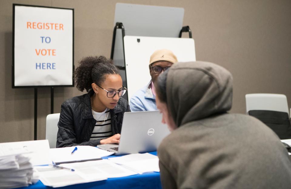 Assistant public defenders work with people during an expungement clinic and job fair at the Route 9 Library and Innovation Center Thursday, April 28, 2022. 