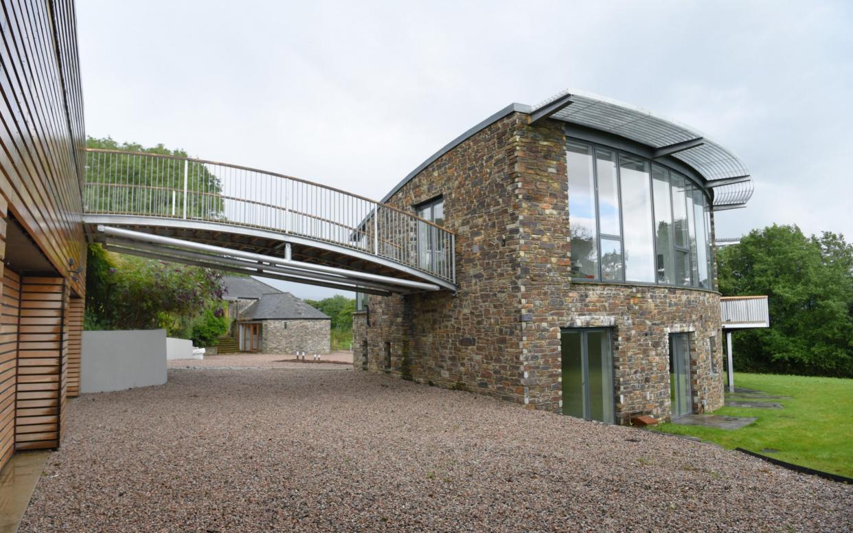 An arched metal and timber bridge leads from the sitting room to a secluded upper garden above the garages at Wortham - COPYRIGHT JAY WILLIAMS