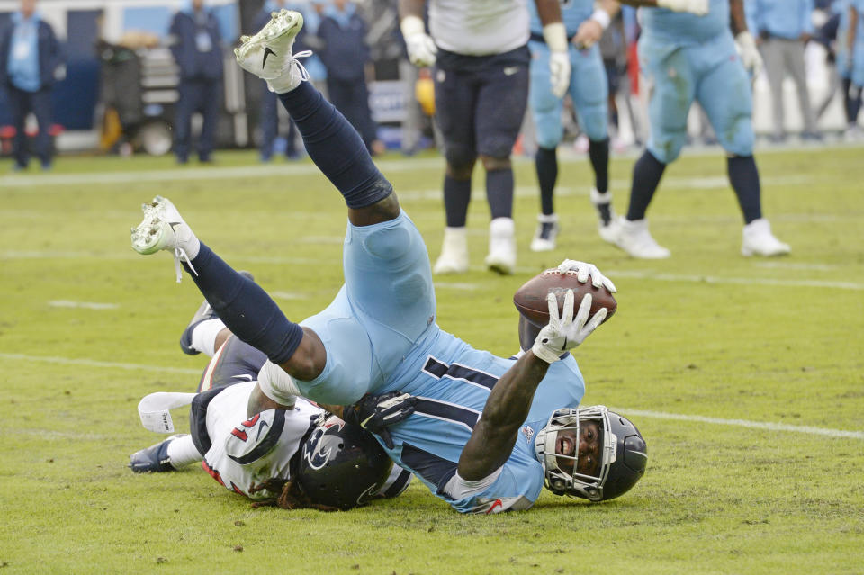 Tennessee Titans wide receiver A.J. Brown (11) is hit by Houston Texans cornerback Bradley Roby (21) as Brown scores a touchdown in the second half of an NFL football game Sunday, Dec. 15, 2019, in Nashville, Tenn. (AP Photo/Mark Zaleski)