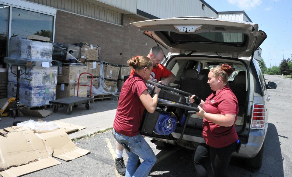 Lindsey Schnedetz and Victoria Hessy help Tad Dilyard, who is from the Moreland area, load a generator into his car. He bought the generator from Everything Surplus in Wooster, where store Manager Schnedetz said they have sold over 200 generators in the past three days.