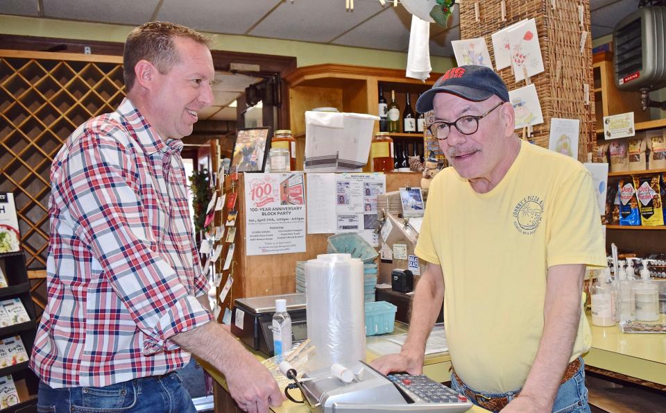 Paul Corderman, left, and John Gordon reminisce across the counter at Gordon's Grocery, which marks its 100-year milestone this month.