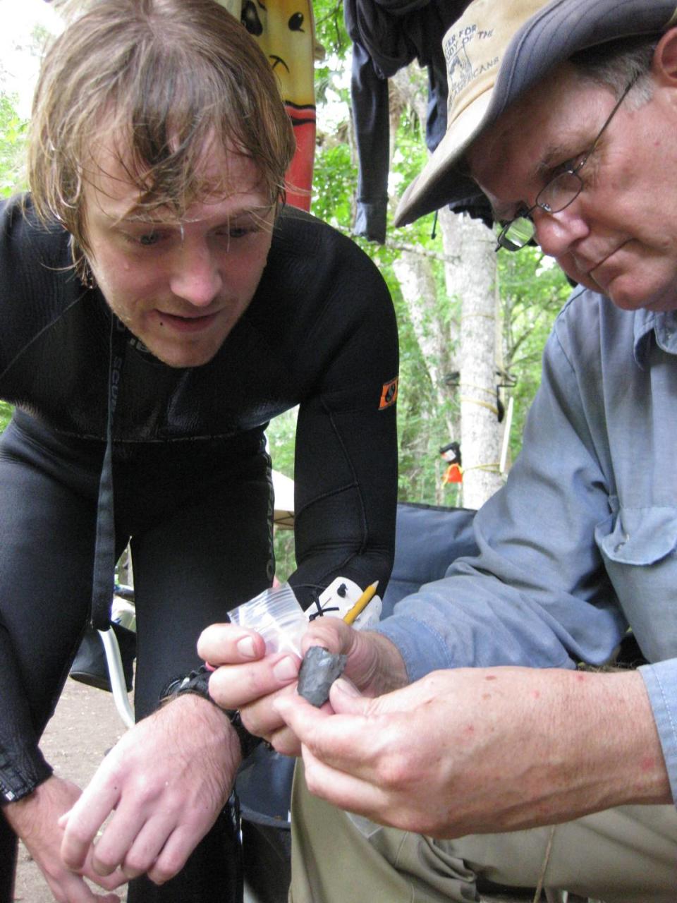 Morgan Smith (left), an associate professor of anthropology at the University of Tennessee at Chattanooga, and Michael R. Waters, an archaeology professor at Texas A&M University, examine a 14,500-year-old stone knife discovered in the Aucilla River by Smith and his dive buddy John Albertson.