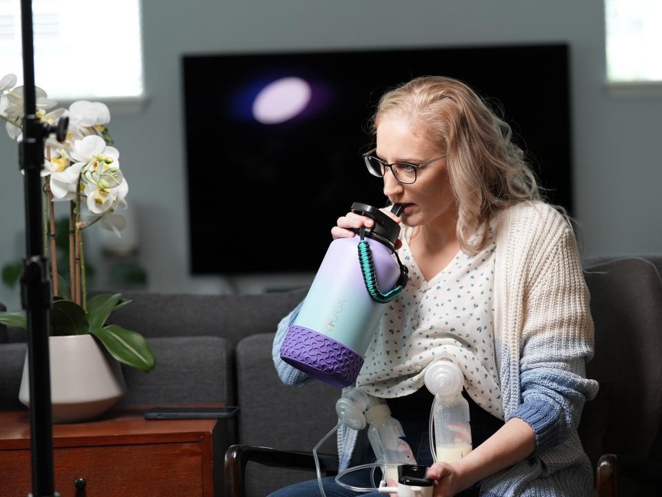 Elisabeth Anderson-Sierra, who donates breastmilk to babies, drinking out of a water bottle while using her breast pump,