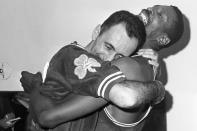 FILE - In this April 24, 1963, file photo, Bill Russell, right, hoists teammate Bob Cousy in a victory hug in the Boston dressing room after the Celtics won their fifth consecutive NBA championship, beating the Lakers 112-109 in Los Angeles. (AP Photo/Ed Widdis, File)