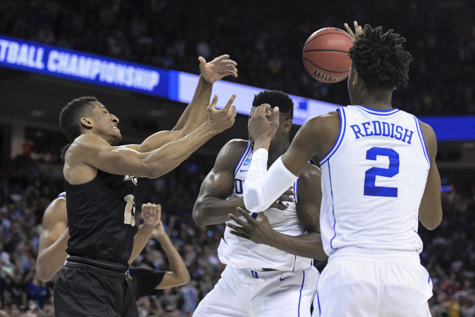 Central Florida guard Aubrey Dawkins, left, battles for a rebound against Duke's Zion Williamson, and Cam Reddish (5) after missing a potential game-winning tip-in during the second half of a second-round game in the NCAA men's college basketball tournament Sunday, March 24, 2019, in Columbia, S.C. Duke defeated Central Florida 77-76. (AP Photo/Sean Rayford)