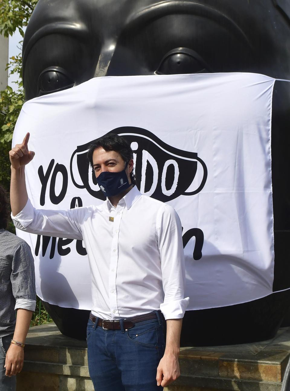 In this June 8, 2020 photo, Mayor Daniel Quintero, wearing a protective face mask as a measure to curb the spread of the new coronavirus, talks to the media during a COVID-19 prevention campaign, in Medellin, Colombia. Quintero, Medellin's youngest mayor ever, is an engineer by training who began holding COVID-19 prep meetings in January, weeks after taking office. The virus was a blip on the radar for most Latin American governments back then. (AP Photo/Luis Benavides)