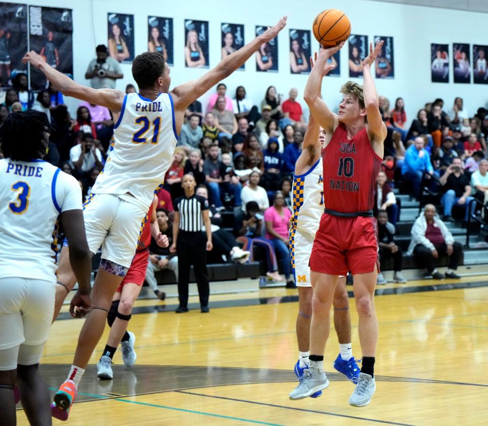 New Smyrna Beach's Lukas Parschauer (10) shoots a jump shot over the arm of Mainland's DeAndre Newland (21) during the Five Star Conference Tournament finals at Atlantic High School in Port Orange, Friday, Jan. 26, 2024.