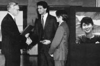 FILE - Alexander and Kim Aris, center, the sons of imprisoned Nobel Peace Prize laureate Aung San Suu Kyi, shown in poster at right, accepts the Nobel Peace Prize from the head of the Norwegian Nobel Peace Prize Committee, Francis Sejersted during the award ceremony in Oslo, Norway, on Dec. 10, 1991. The Myanmar opposition leader was in house arrest for participating in anti-government protests when she was awarded the 1991 Nobel Peace Prize. (AP Photo/Bjoern Sigurdsoen, File)