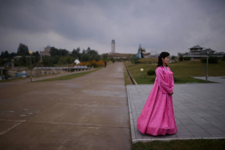 A North Korean tour guide wearing a traditional 'hanbok' dress waits for visitors at a 'Folk Park' on the outskirts of Pyongyang on October 11, 2015