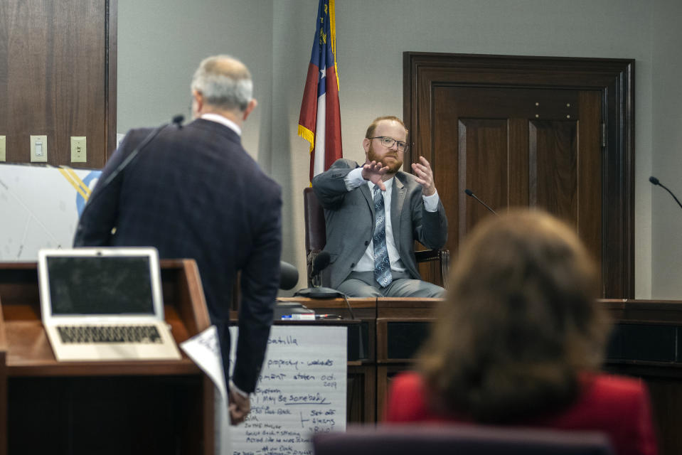 Travis McMichael, center, is questioned by his defense attorney Jason B. Sheffield, left, while on the witness stand during the trial of he, his father Greg McMichael and neighbor William "Roddie" Bryan in the Glynn County Courthouse, Wednesday, Nov. 17, 2021, in Brunswick, Ga. The three are charged with the February 2020 slaying of 25-year-old Ahmaud Arbery. (AP Photo/Stephen B. Morton, Pool)