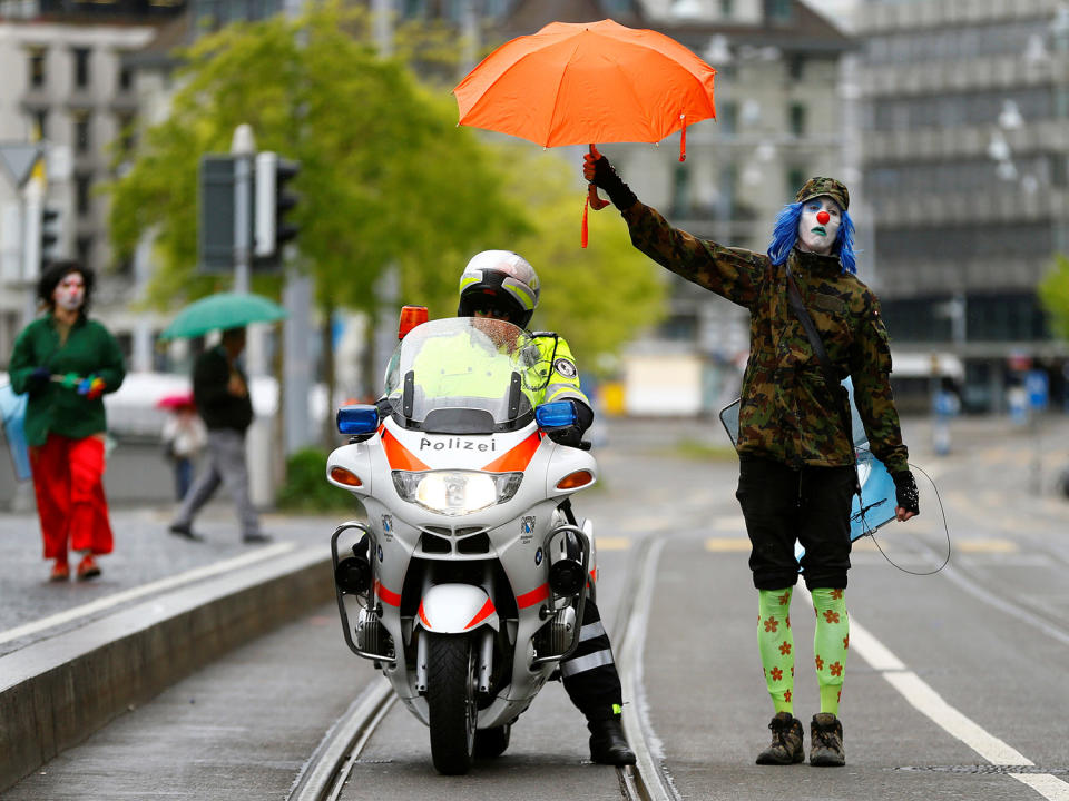 Protester holding umbrella over police officer