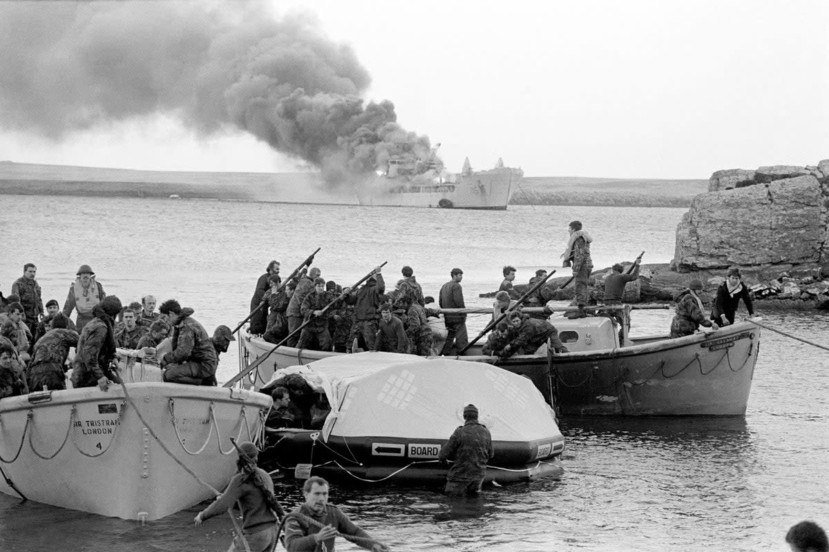 Survivors coming ashore from the Sir Galahad, after it was hit by an Argentinian air attack at Bluff Cove, the Falkland Islands (PA)