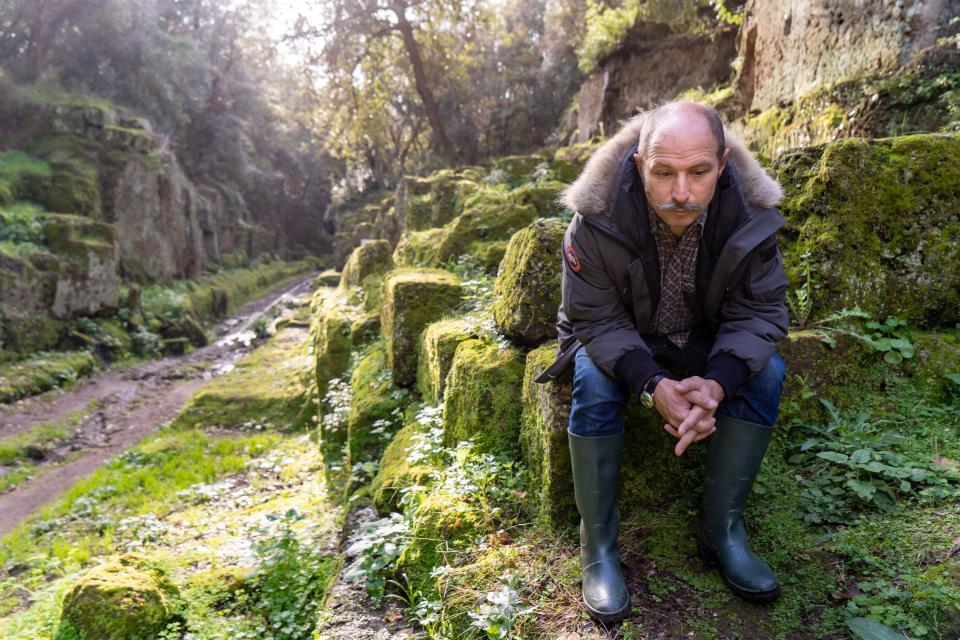 Cinematographer Steeven Petitteville sits among the tombs where the Antefix was looted from in Banditaccia, outside of Rome.