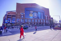 FILE - Fans pose with a Final Four logo before a college basketball game during the Final Four round of the NCAA tournament at Lucas Oil Stadium in Indianapolis, in this Saturday, April 3, 2021, file photo. A law firm hired to investigate gender equity concerns at NCAA championship events released a blistering report Tuesday, Aug. 3, 2021, that recommended holding the men's and women's Final Fours at the same site and offering financial incentives to schools to improve their women's basketball programs. (AP Photo/AJ Mast, File)