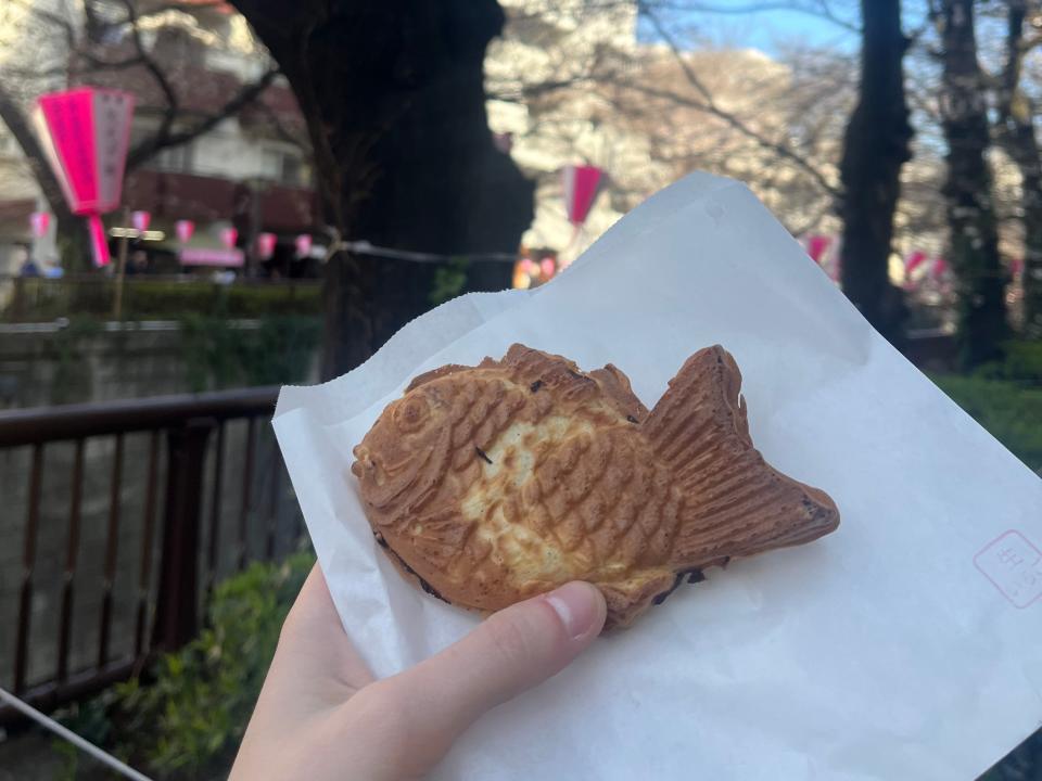 hand holding up a fish shaped treat in japan