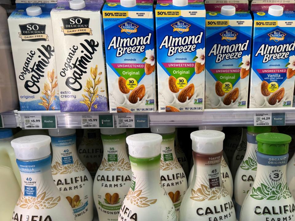 Coffee creamers, oat milk, and Almond Breeze on shelves at Whole Foods
