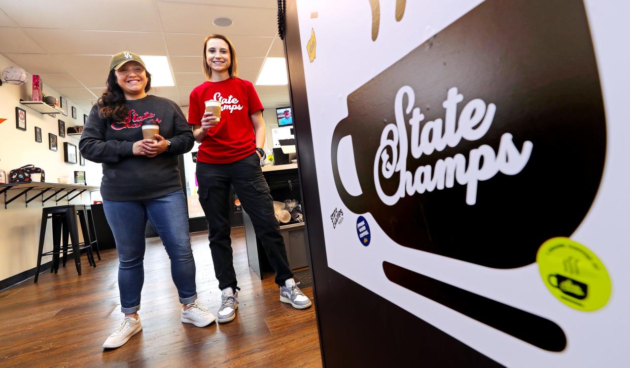 Ally Eclarin, left, and Cassy Kopp, co-owners of State Champs, pose for a portrait in their sports-themed coffee shop in Kent.