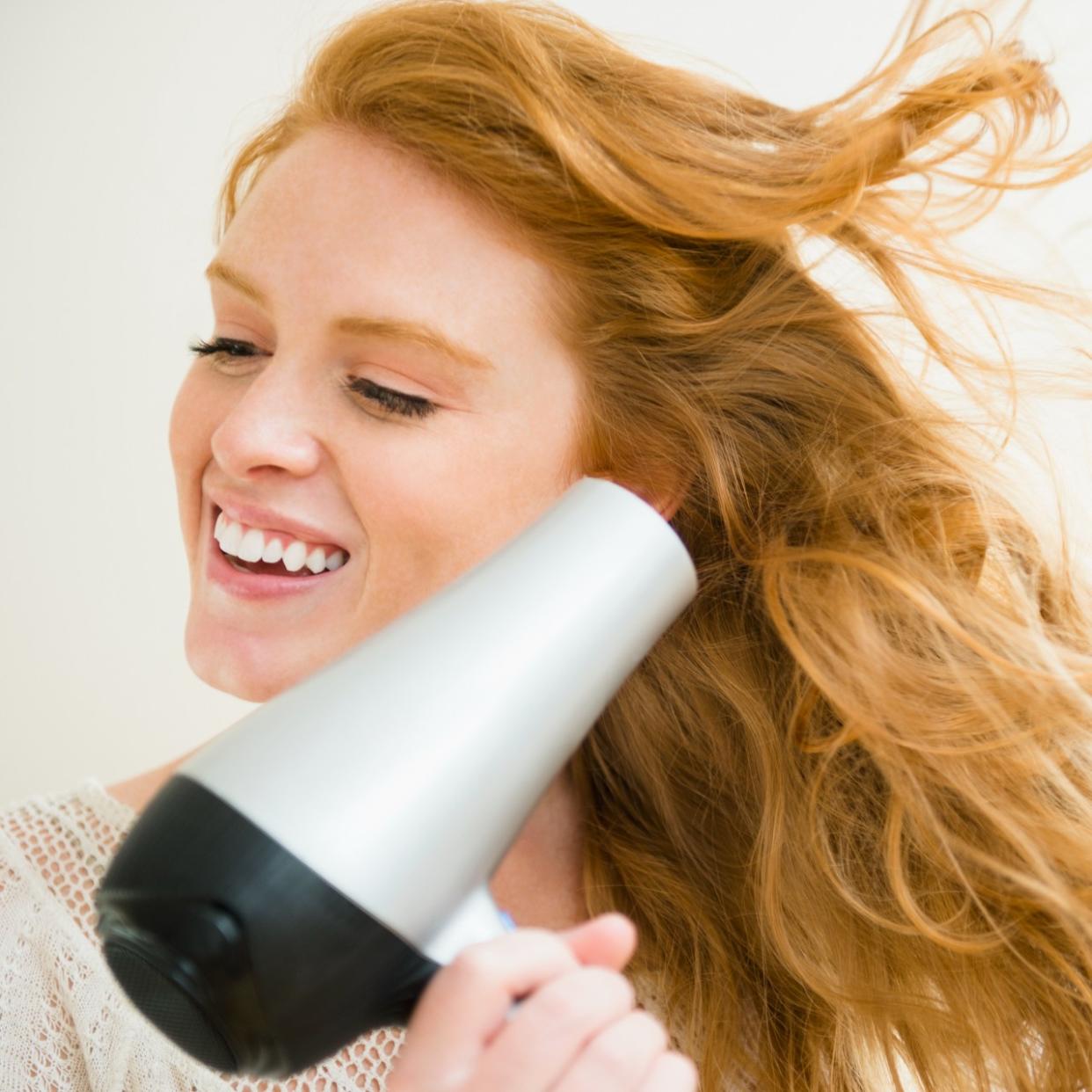  Woman blow drying hair 