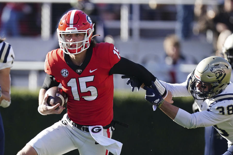 Georgia quarterback Carson Beck (15) tries to escape from Charleston Southern linebacker Kyle Syvarth (38) in the second half of an NCAA college football game Saturday, Nov. 20, 2021, in Athens, Ga.. (AP Photo/John Bazemore)