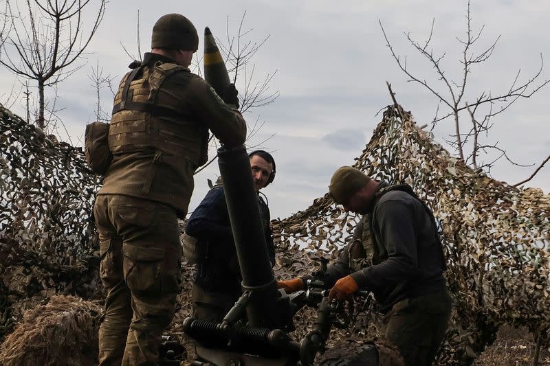 FILE PHOTO: Ukrainian service members load a shell to a mortar before firing towards Russian troops outside the frontline town of Bakhmut